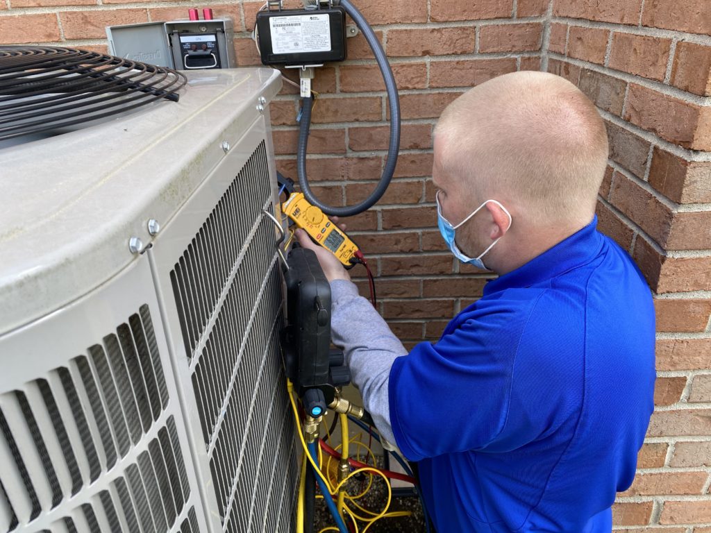 A National technician working on an air conditioner